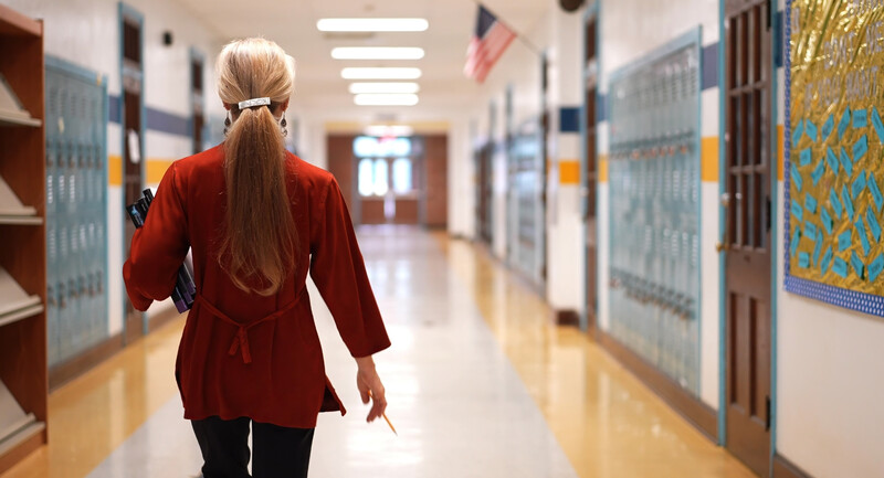 A middle school leader walking down a hallway with purpose in their stride.